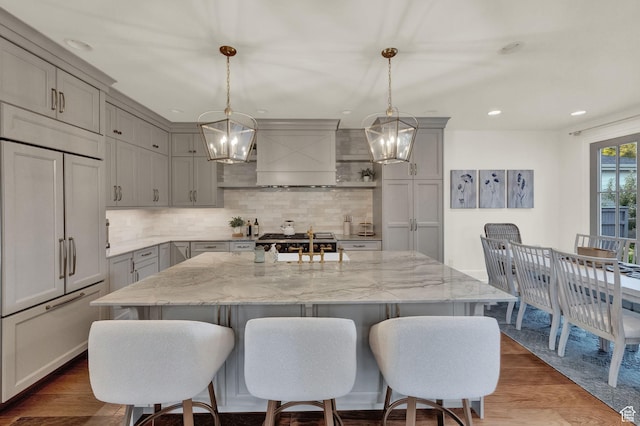 kitchen with gray cabinetry, a breakfast bar, and an inviting chandelier