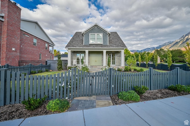 bungalow-style home with a mountain view, a gate, and a fenced front yard