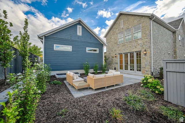 rear view of property featuring a patio area, stone siding, fence, and an outdoor hangout area