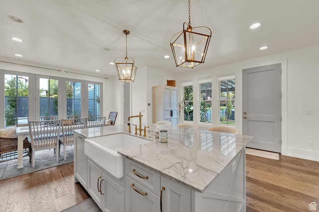 kitchen featuring dark wood-style flooring, a chandelier, recessed lighting, pendant lighting, and a sink