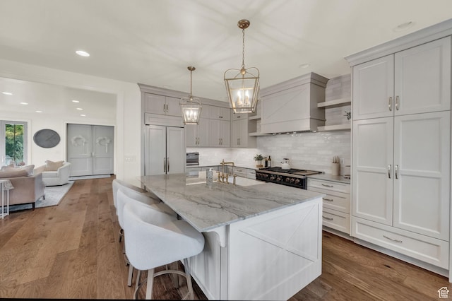 kitchen featuring a center island, open shelves, premium range hood, dark wood-type flooring, and decorative backsplash