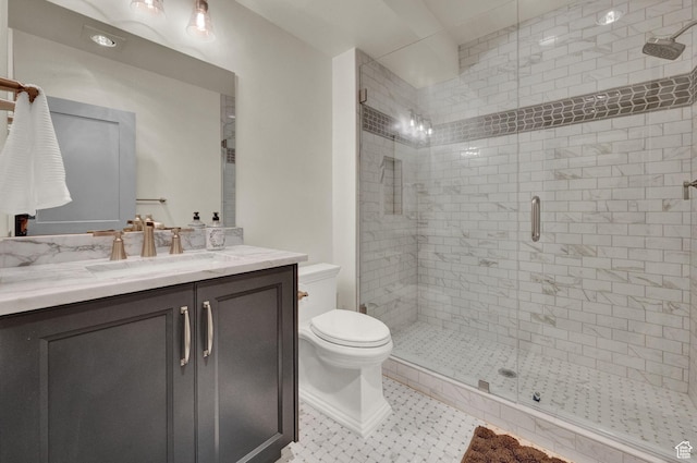bathroom with tile patterned floors, toilet, vanity, and a stall shower