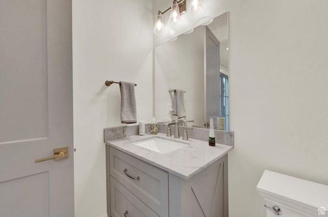 half bath featuring vanity and toilet