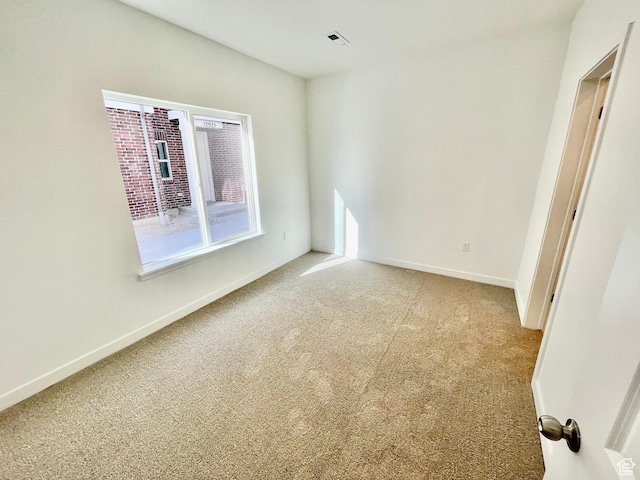 empty room with baseboards and light colored carpet