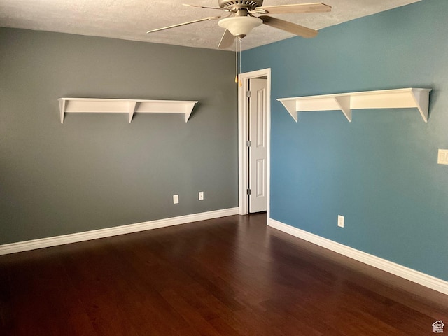 unfurnished room with ceiling fan, a textured ceiling, baseboards, and dark wood finished floors