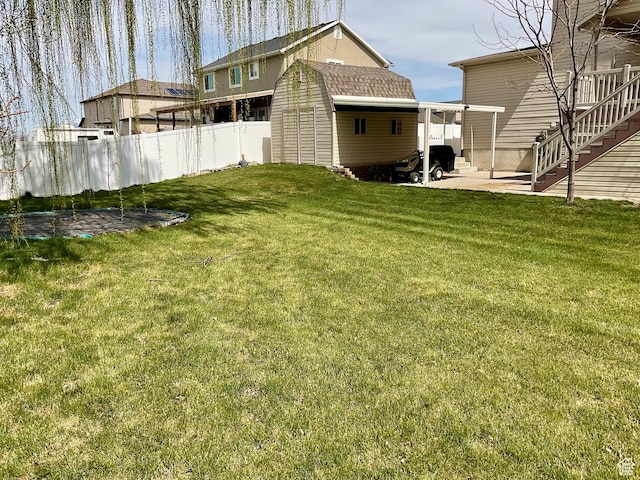 view of yard featuring an outbuilding, fence, a patio, and stairs