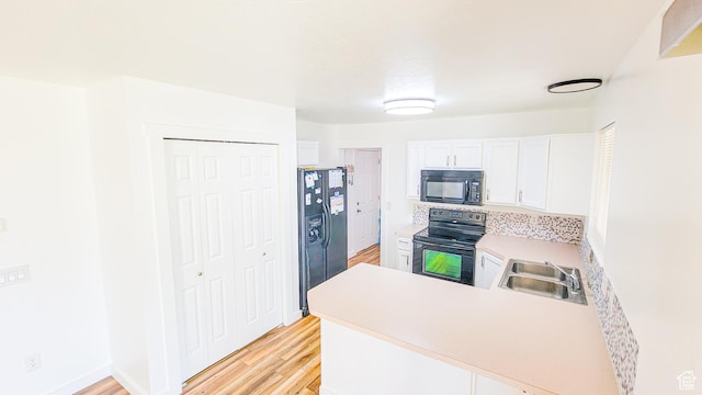 1701 N 810 W, Clinton, UT 84015 - kitchen with a peninsula, light countertops, black appliances, light wood-style floors, and a sink