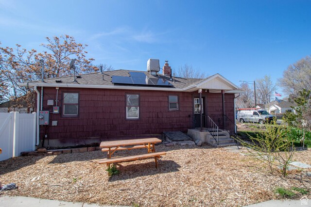 180 E Southgate Ave S, Salt Lake City, UT 84115 - back of property with roof with shingles, fence, a chimney, and roof mounted solar panels
