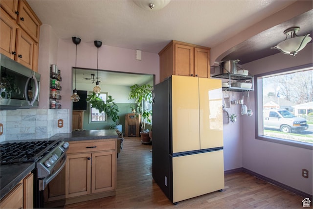 180 E Southgate Ave S, Salt Lake City, UT 84115 - kitchen with dark countertops, light wood-type flooring, appliances with stainless steel finishes, and decorative backsplash