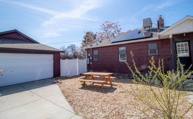 180 E Southgate Ave S, Salt Lake City, UT 84115 - view of home's exterior featuring a gate, a shingled roof, solar panels, and a garage