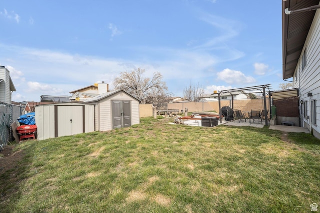 view of yard featuring an outdoor structure, a shed, a fenced backyard, and a patio area
