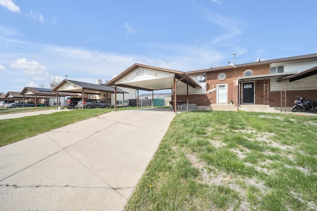 view of front of home featuring concrete driveway, a front yard, brick siding, and fence