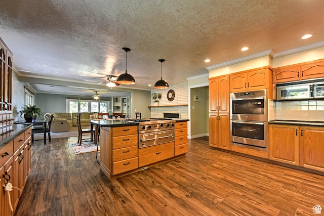 1050 S 200 W, Wellsville, UT 84339 - kitchen featuring dark wood-style flooring, open floor plan, a ceiling fan, dark countertops, and appliances with stainless steel finishes