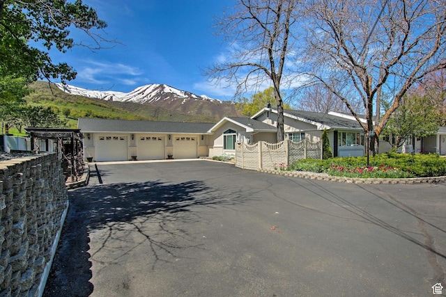 1050 S 200 W, Wellsville, UT 84339 - ranch-style house with aphalt driveway, stucco siding, a mountain view, and an attached garage