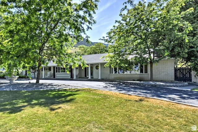 1050 S 200 W, Wellsville, UT 84339 - view of front of property featuring driveway, a front yard, fence, and brick siding