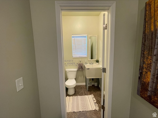 half bath featuring toilet, tile patterned floors, and baseboards