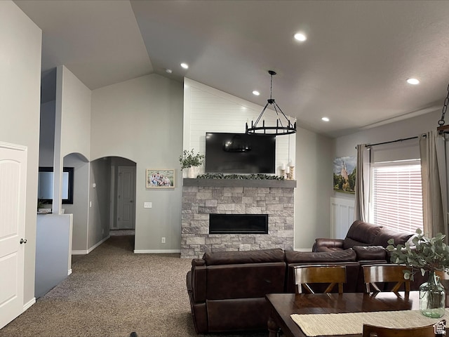 living room featuring carpet flooring, a fireplace, arched walkways, recessed lighting, and baseboards