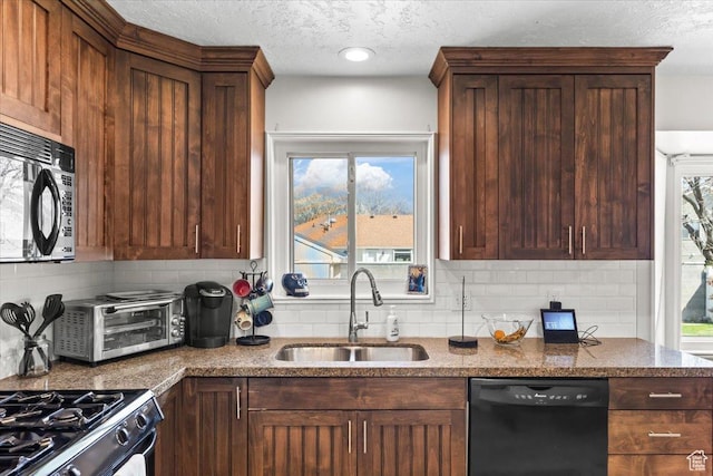 kitchen with tasteful backsplash, a sink, black appliances, and dark stone countertops