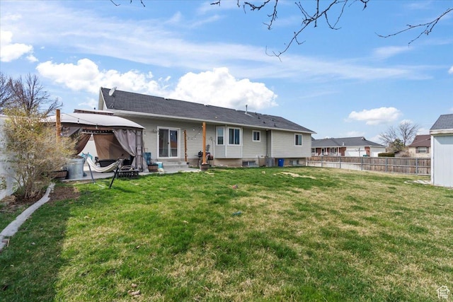 rear view of house featuring a gazebo, a patio area, fence, and a lawn