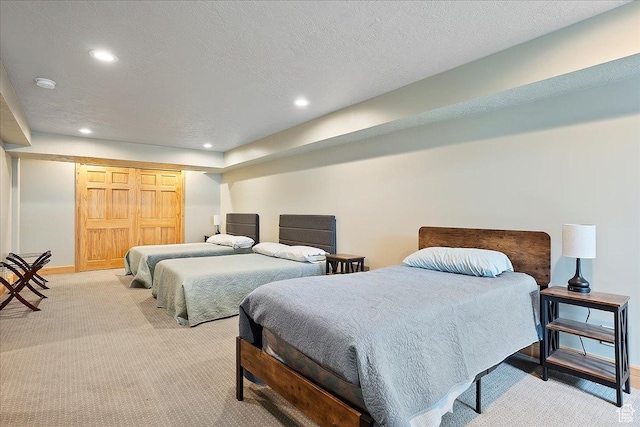 bedroom with baseboards, recessed lighting, light carpet, and a textured ceiling