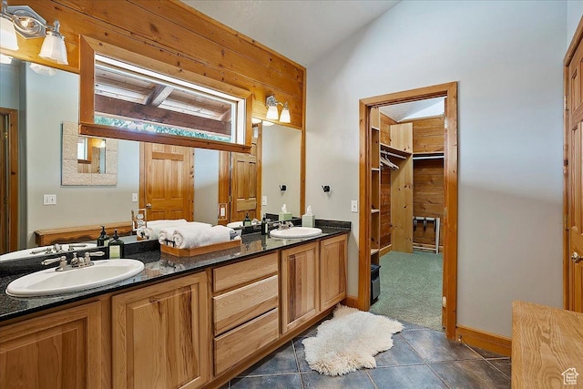 full bathroom featuring tile patterned floors, double vanity, a sink, and lofted ceiling