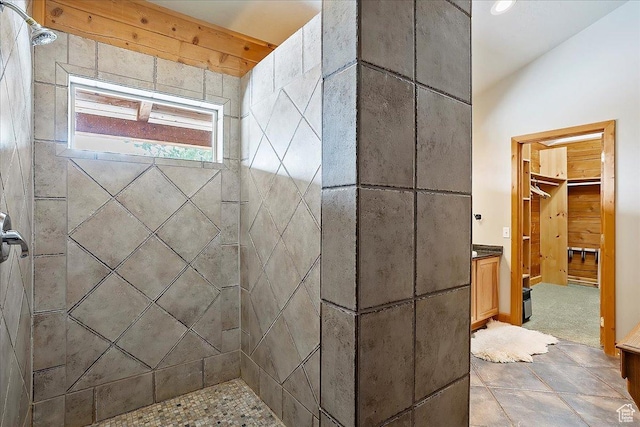 bathroom with a spacious closet and tiled shower