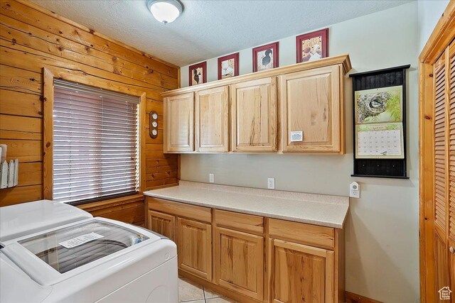 laundry room featuring a textured ceiling, separate washer and dryer, and cabinet space