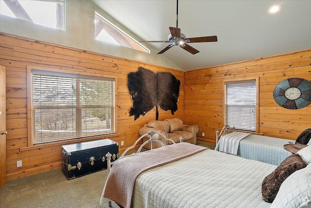 carpeted bedroom with wood walls, vaulted ceiling, and ceiling fan