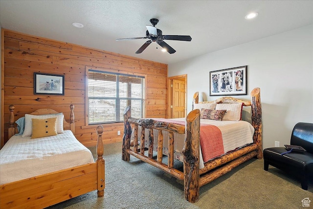 bedroom with wooden walls, a ceiling fan, and carpet