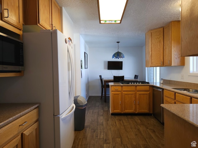 149 Toponce Dr, Evanston, WY 82930 - kitchen featuring a peninsula, dark wood-style floors, a textured ceiling, brown cabinets, and stainless steel dishwasher
