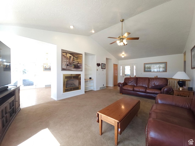 149 Toponce Dr, Evanston, WY 82930 - living room with ceiling fan with notable chandelier, a fireplace, a textured ceiling, light colored carpet, and vaulted ceiling