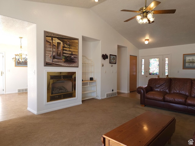 149 Toponce Dr, Evanston, WY 82930 - carpeted living area featuring visible vents, a glass covered fireplace, vaulted ceiling, and ceiling fan with notable chandelier
