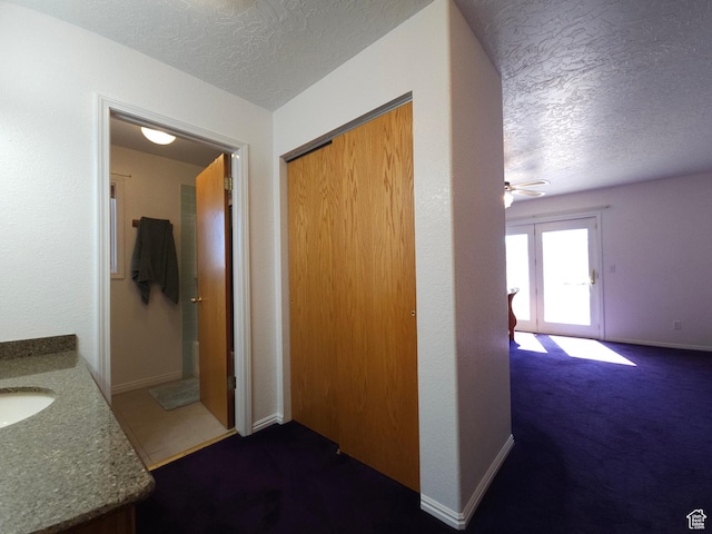 149 Toponce Dr, Evanston, WY 82930 - hall with a textured ceiling, a sink, baseboards, and dark colored carpet
