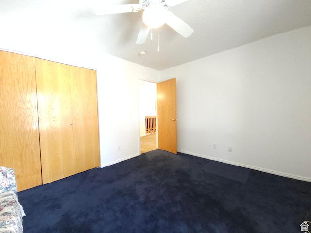 149 Toponce Dr, Evanston, WY 82930 - unfurnished bedroom featuring dark carpet, baseboards, a ceiling fan, and a closet