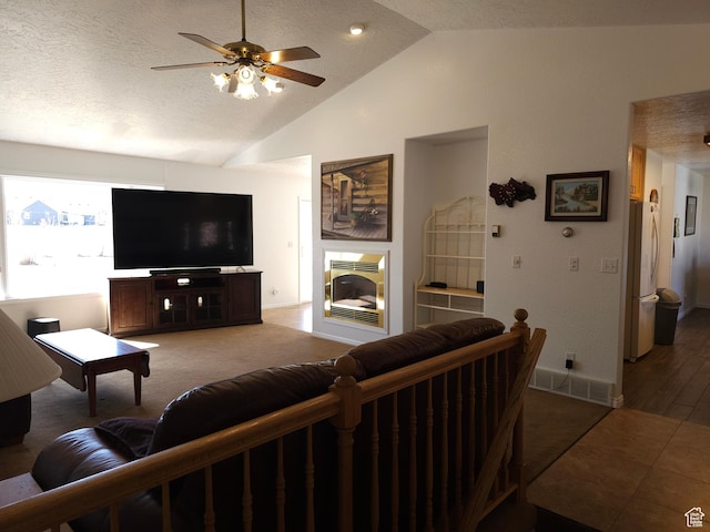149 Toponce Dr, Evanston, WY 82930 - living area with ceiling fan, a fireplace, a textured ceiling, visible vents, and lofted ceiling