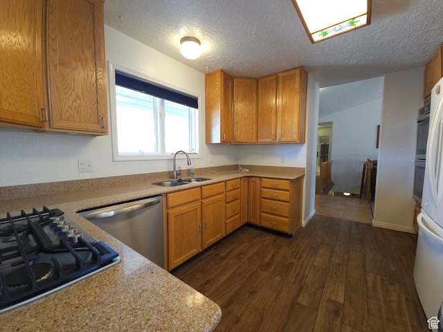 149 Toponce Dr, Evanston, WY 82930 - kitchen with dark wood-style floors, light countertops, a textured ceiling, stainless steel appliances, and a sink