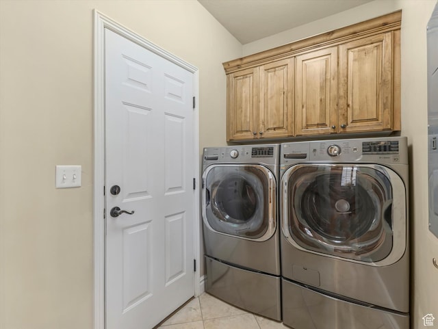 laundry room featuring independent washer and dryer, light tile patterned floors, and cabinet space