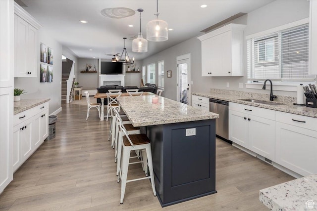1379 E Hollyhock Ct, Layton, UT 84040 - kitchen featuring stainless steel dishwasher, white cabinets, a sink, and a kitchen island