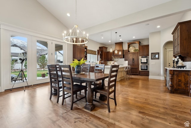 dining space with recessed lighting, light wood-style floors, a chandelier, and high vaulted ceiling