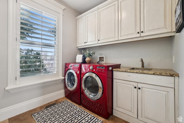 laundry area featuring cabinet space, a wealth of natural light, baseboards, and a sink