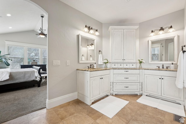 ensuite bathroom featuring ensuite bath, ceiling fan, a sink, and double vanity
