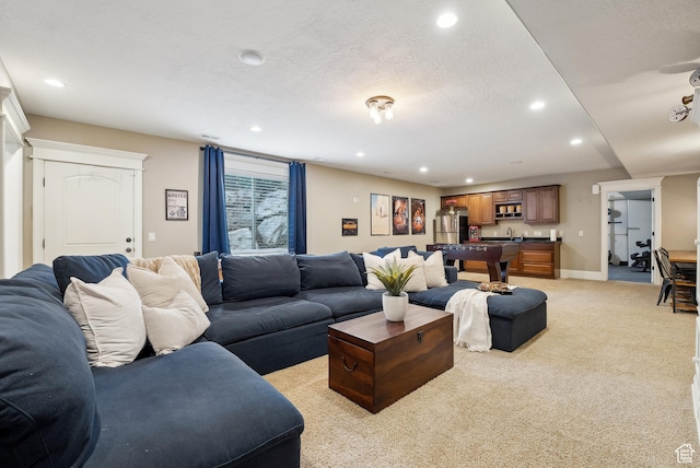 living area featuring baseboards, light carpet, and recessed lighting