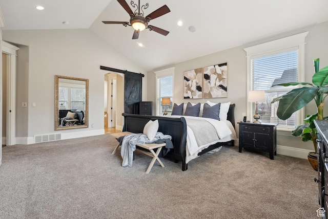 bedroom featuring light colored carpet, visible vents, a barn door, and baseboards