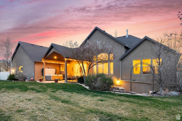 view of front of home featuring a patio area, stucco siding, and a lawn