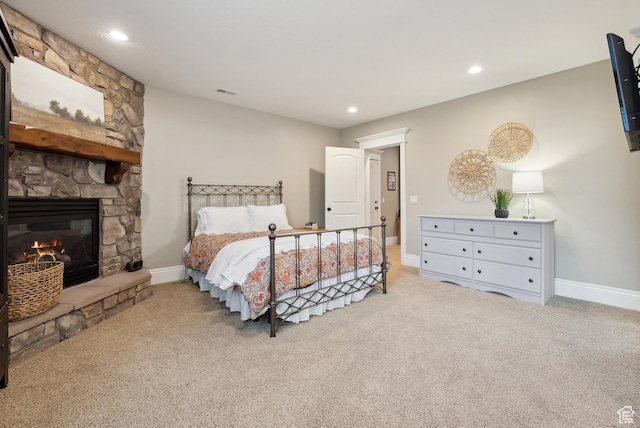 bedroom with carpet, visible vents, a stone fireplace, and recessed lighting