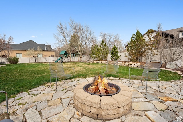 view of patio / terrace featuring a fenced backyard, an outdoor fire pit, and a playground