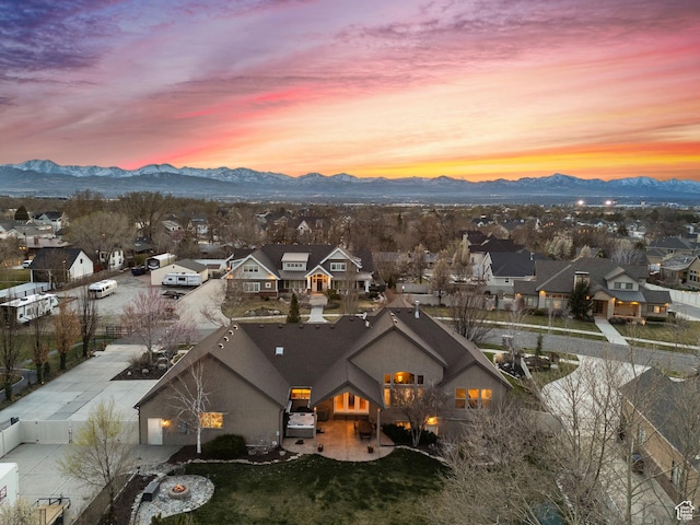 aerial view at dusk featuring a mountain view and a residential view
