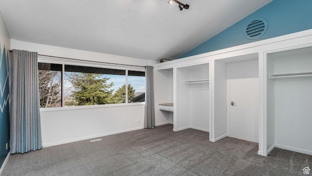 unfurnished bedroom featuring multiple closets, carpet, vaulted ceiling, and baseboards