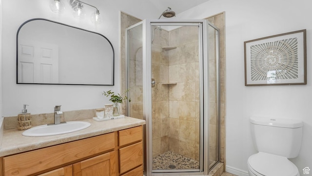 full bath featuring toilet, vanity, and a stall shower