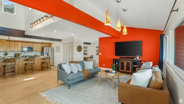 living area with light wood-style flooring, recessed lighting, and a towering ceiling